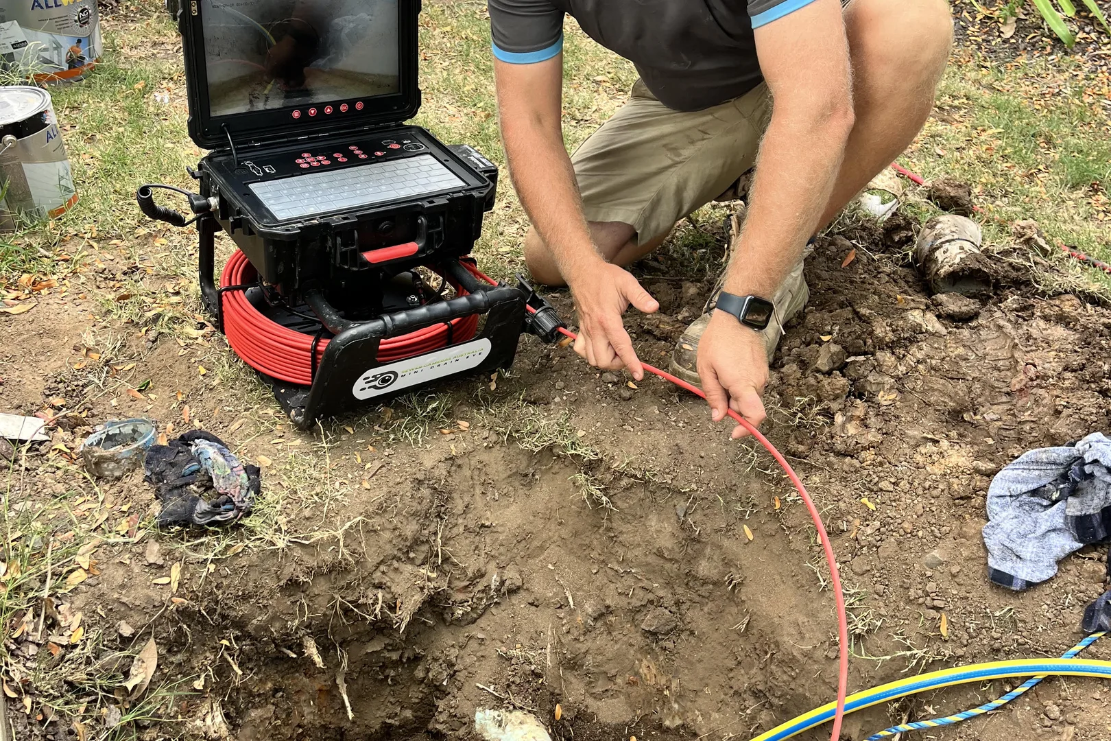 Flow plumber feeding a drain camera into an open pit