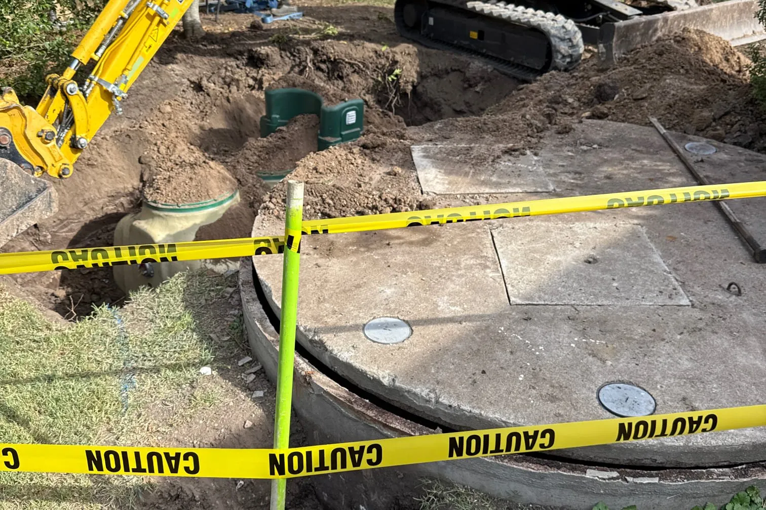 Excavator digging a taped-off pit in a backyard