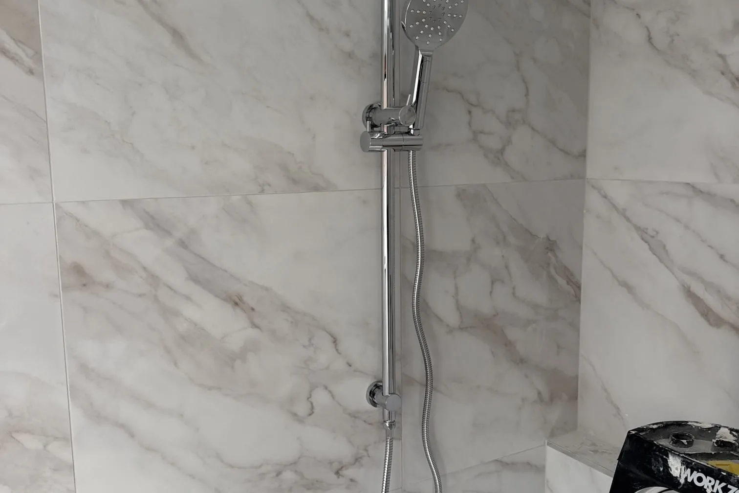 New shower rail and mixer on a tiled wall