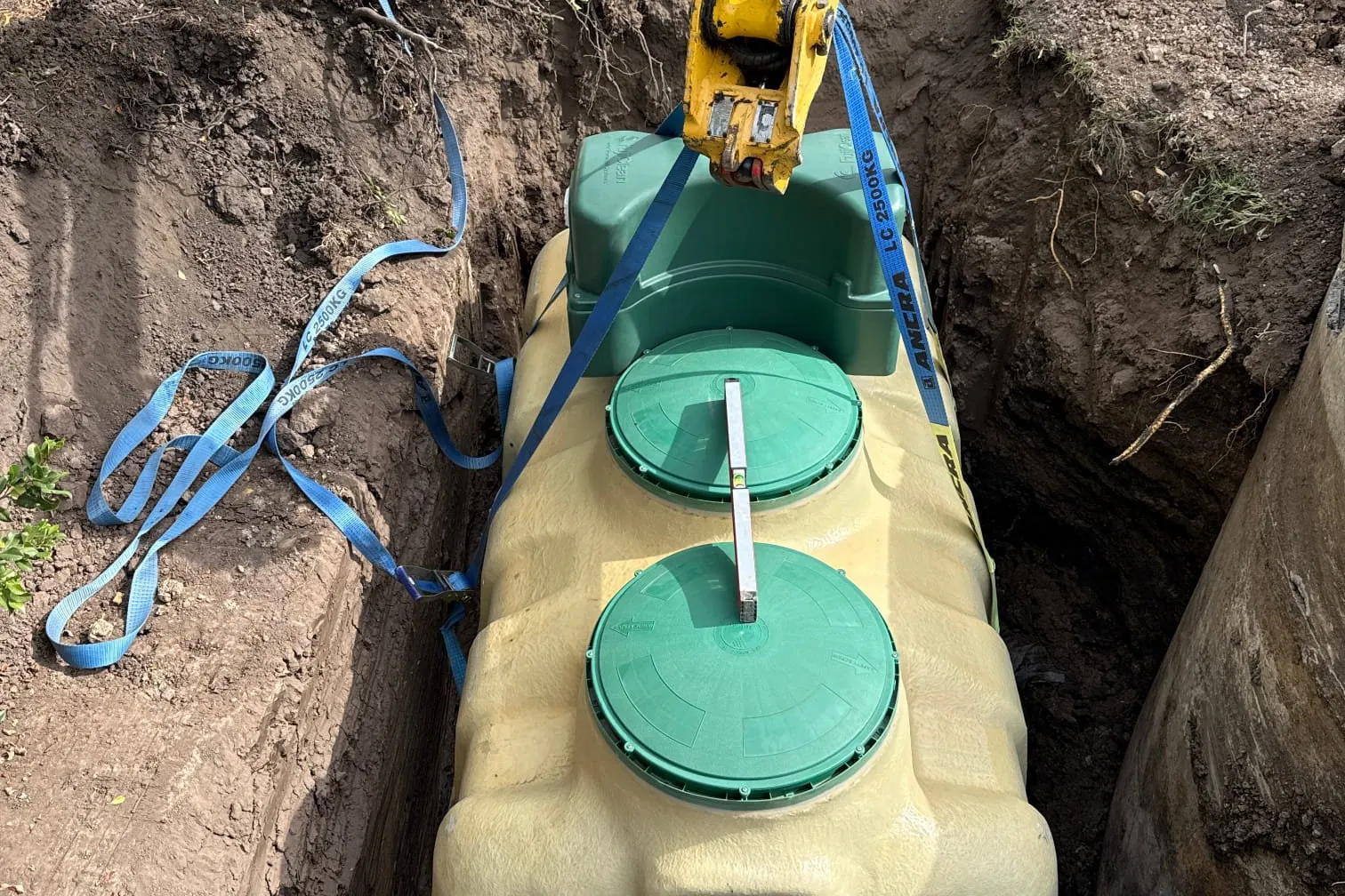 Septic tank being lowered into an excavated pit