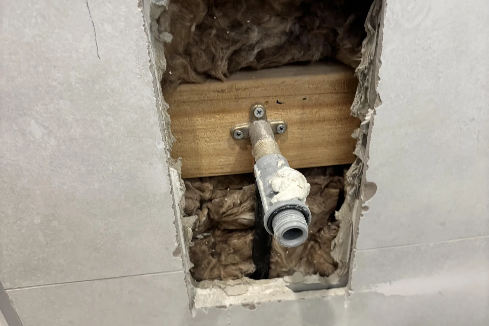 Wall opened up to move a water pipe for a toilet and basin
